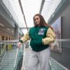 Student wearing green varsity jacket with the Nipissing University crest