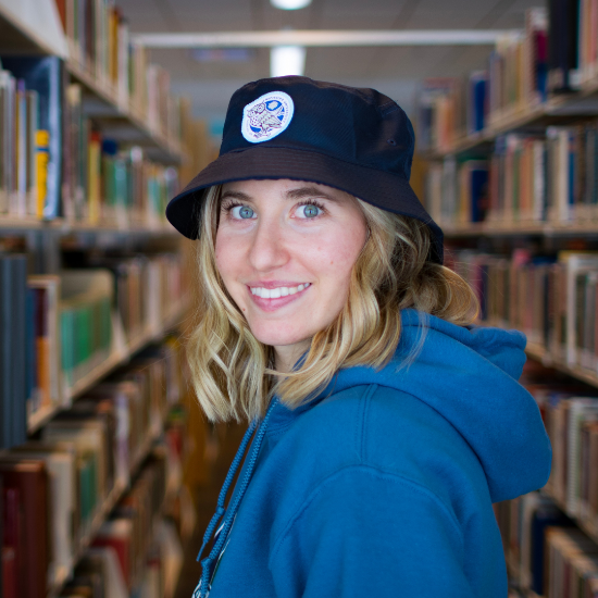 Student wearing navy blue bucket hat featuring the NU Owl