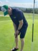 Student golfing in a Lakers Golf Shirt