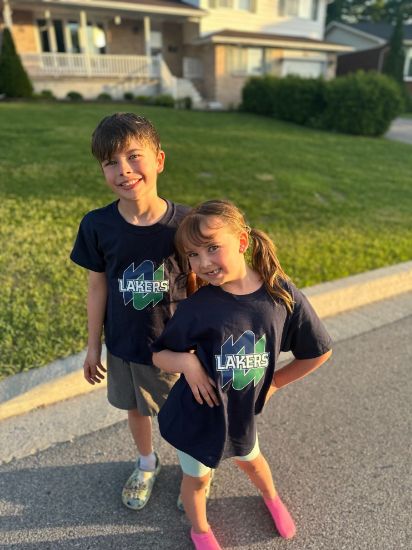 Two children wearing Navy tee-shirts with the NU Lakers logo on the front