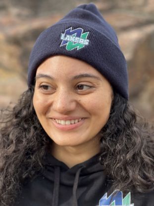 Student smiling with a Navy Lakers Beanie.