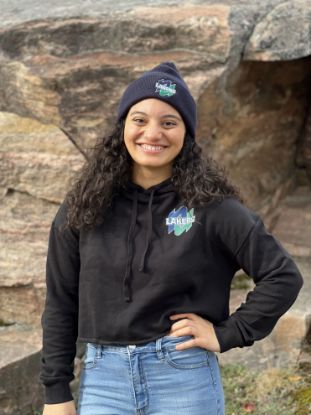 Student wearing a cropped Lakers hoodie in front of a rock